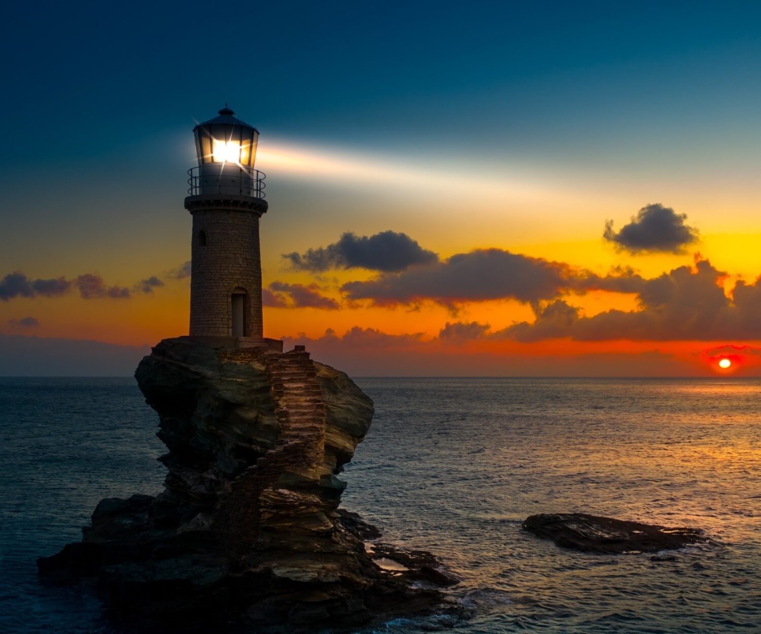 Lighthouse signals safe harbor on rocky shoreline